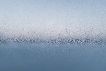 Snow patterns on the glass, close-up. Fancy patterns drawn on a frosty winter day. Frost texture from the ice crystals on the glass of the window. Space for your design or text. High quality photoの写真素材