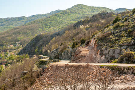 The serpentine road in the green mountains. Landscape view perspective of mountain road with blue sky for publication, poster, calendar, post, screensaver, wallpaper, postcard, banner, cover, websiteの写真素材