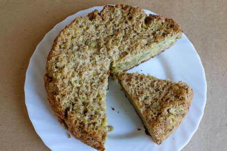 A pieces of apple cake on a white plate, top view. Homemade bakery. Culinary template. Charlotte pie for publication, design, poster, calendar, screensaver, wallpaper, card, banner, cover, websiteの写真素材