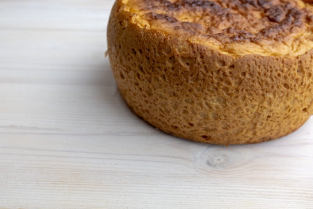 Freshly baked bread on white table, side view. A round bread lies on the right side of surface for...