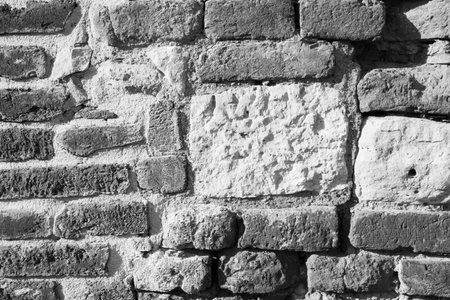 Black and white stone wall for background design. Vintage of stone backdrop. Natural stone wall textured background for a poster, calendar, screensaver, wallpaper, postcard, banner, cover, websiteの写真素材