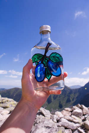 Plum Brandy in Sad Saddle in Mountains Rohace Western Tatras in Slovak Republic, background tops of Placlive and Ostry Rohacの写真素材