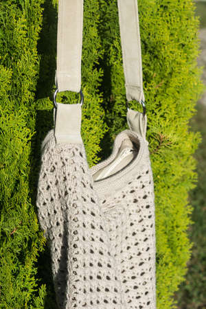 Cream crocheted handbag behind the in the garden in countrysideの写真素材