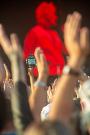 Crowd of people at concert in front of stage lights, blurred backgroundの写真素材