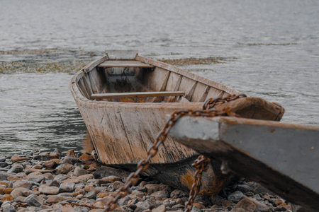 Abandoned wooden boat on the shore of the lake in winter