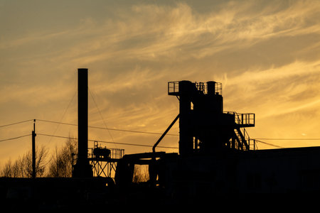 Silhouette of an industrial plant at sunset in the evening.の写真素材