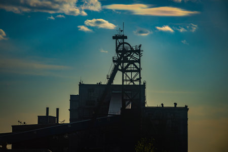 Industrial landscape with silhouettes of cranes against the sunset skyの写真素材