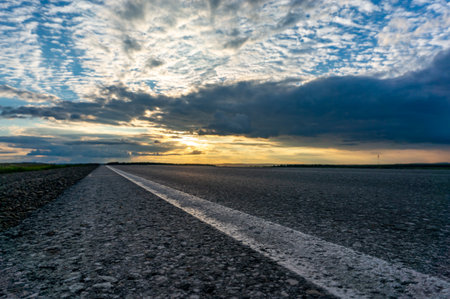 Asphalt road and sky with clouds at sunset. landscape.の写真素材
