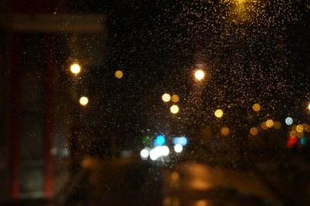 rain drops on the glass with a blurred background of the night cityの写真素材