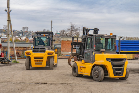 two yellow forklifts while working on cargo transportationの写真素材