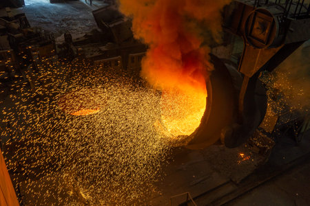 Hot molten steel being poured into a mold in a metallurgical plant