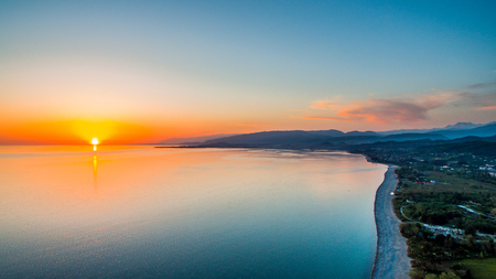Flaming sunset over the sea taken from the height of bird flightの写真素材