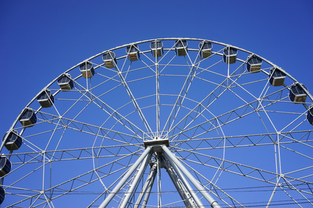 Ferris wheel Ferris wheel with closed cabins on the background of bright blue skyの写真素材