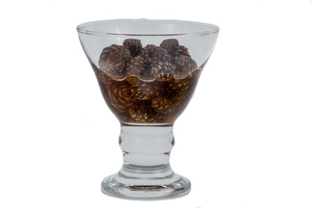glass ramekin of jam made from pine cones on a white backgroundの写真素材