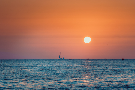 Bright sunset on the sea background sea and boats in the blue seaの写真素材