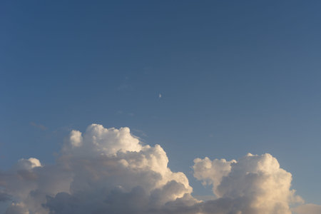 Natural background with clouds and a moon on the background of blue sky in clear weather