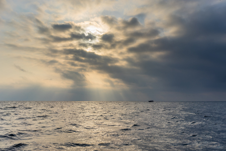 The sea in cloudy and foggy weather with floating boatの写真素材