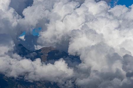 White fluffy clouds on the tops of mountains.の写真素材