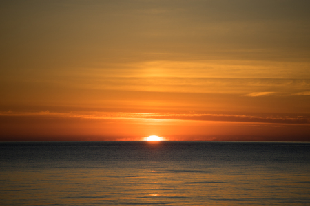 Bright dramatic sunset on the background of the calm sea.の写真素材