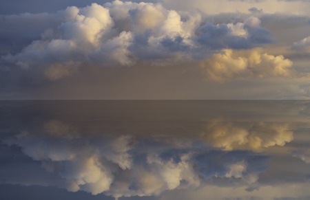 natural background with beautiful cloudy sky reflected in calm water surface.の写真素材