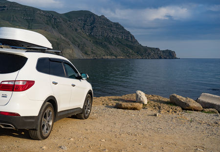 A large white car in front of the sea at the mountain Meganom in Crimea.の写真素材