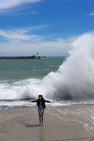 Yalta, Crimea-may 30, 2018: A young girl rejoices in the background of the sea and waves.のeditorial素材