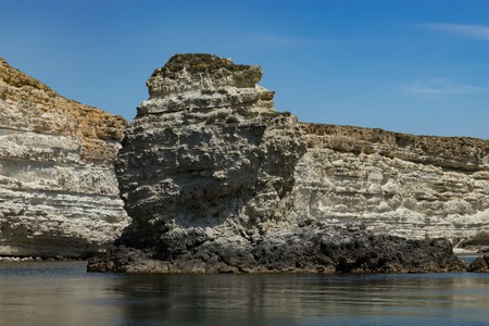 Rocks and stones against the sea under the blue sky at Cape Tarkhankut in the Crimea.の写真素材