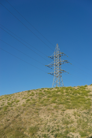 electric tower with wires on the hill against the blue sky.の写真素材