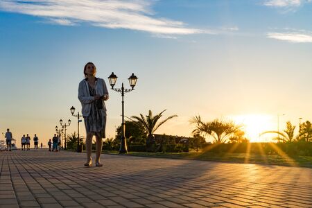 Sochi, Russia-June 9, 2018: People walk along the Imeretinskaya embankment at sunset.のeditorial素材