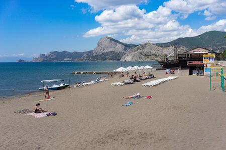 Sudak, Crimea-may 22, 2018: Public beach with people on a Sunny day under the blue sky..のeditorial素材