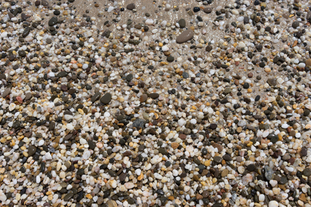 Natural background of small colored pebbles on the beachの写真素材