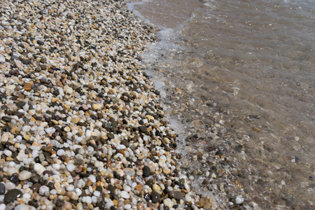 Natural background of small colored pebbles on the beachの写真素材