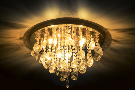 Bright orange crystal chandelier on dark backgroundの写真素材