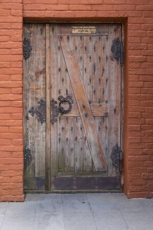 Sochi, Russia-September 24, 2017: Wooden door on a stone wall with a sign.のeditorial素材