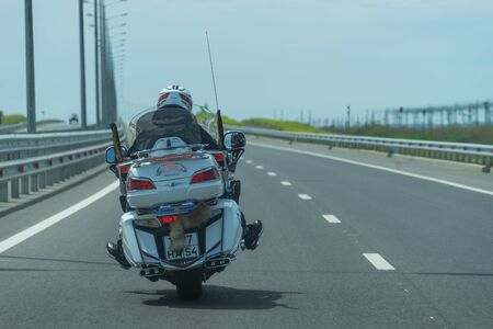 Krasnodar region, Russia-may 19, 2018: motorcyclist on a white motorcycle rides on a new road in the direction of the Crimea.のeditorial素材
