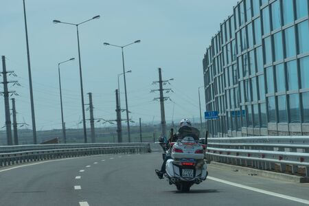 Krasnodar region, Russia-may 19, 2018: motorcyclist on a white motorcycle rides on a new road in the direction of the Crimea.のeditorial素材