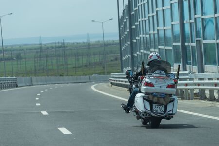 Krasnodar region, Russia-may 19, 2018: motorcyclist on a white motorcycle rides on a new road in the direction of the Crimea.のeditorial素材