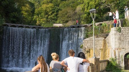 Tourists admire the streams of an artificial waterfall made by monks.のeditorial素材