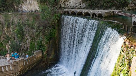 Tourists admire the streams of an artificial waterfall made by monks.のeditorial素材