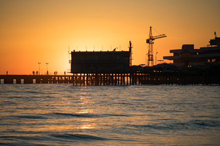 Sukhumi, Abkhazia - January 7, 2017: Bright orange sunset over the sea pier of the city.の写真素材