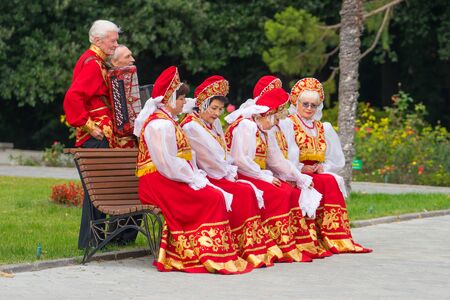 Yalta, Crimea - October 20, 2017: Elderly people in red folk costumes posing for photography.のeditorial素材