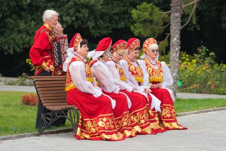 Yalta, Crimea - October 20, 2017: Elderly people in red folk costumes posing for photography.のeditorial素材
