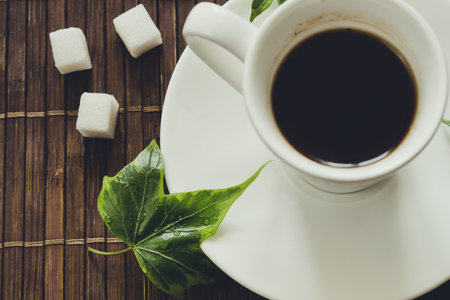 still life with black coffee on a dark background with autumn yellow leaves