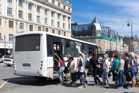 Vladivostok, Russia-August 17, 2018: Urban landscape with a white bus and a queue of passengers.のeditorial素材