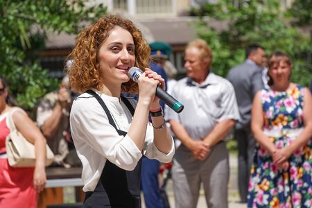 Sukhumi, Abkhazia-may 28, 2015: Young female singer with beautiful red hair singing in the street on the background of people.のeditorial素材