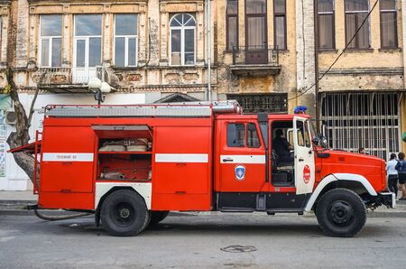 Sukhumi, Abkhazia-may 15, 2015: Red fire truck is on the street in an old building, people are watching the fire.のeditorial素材