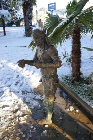 Sukhumi, Abkhazia-January 27, 2017: Urban landscape with sculpture on the background of snow and palm trees.のeditorial素材