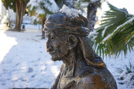 Sukhumi, Abkhazia-January 27, 2017: Urban landscape with sculpture on the background of snow and palm trees.のeditorial素材
