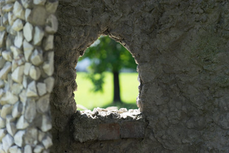 stone background with window and view of blurred green tree.