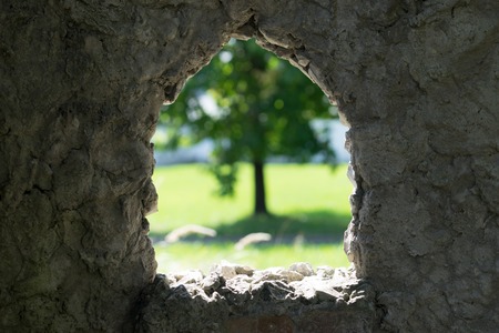 stone background with window and view of blurred green tree.の写真素材